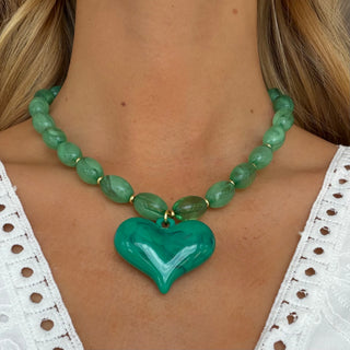 Model wearing Roxie Green Heart Necklace with oversized emerald green heart pendant and marbled green beads front view