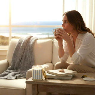 Sea salt candle burning on coffee table in coastal living room with ocean view