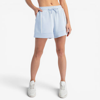 Blue scuba knit A-line shorts with contrast piping and relaxed fit shown with front view.