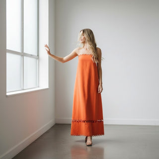 Orange strapless scallop trim maxi dress with cutout hem detail and flowy resort silhouette front view