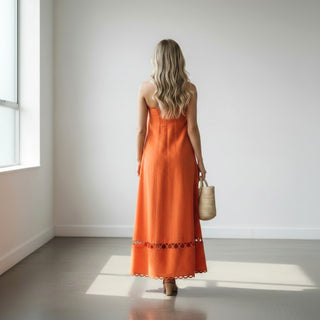 Orange strapless maxi dress with scallop trim and cutout hem detail back view with woven beach tote