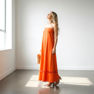 Orange strapless scallop trim maxi dress with flowy silhouette and cutout hem detail side view for resort and vacation wear