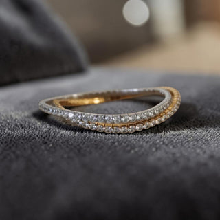Gold and silver stretch tennis bracelet with cz diamonds on a textured surface