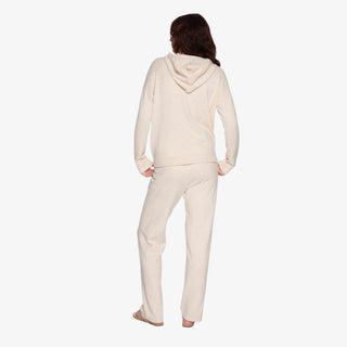 Woman wearing a soft cream sweater hoodie with relaxed fit and lightweight knit design.