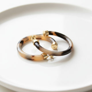 Hoo Hoops tortoise hoop earrings medium size with glossy acrylic finish styled on white tray close-up view