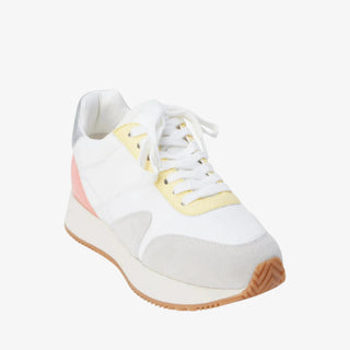 White sneaker with muted grey, yellow and pink colorful accents on a white background