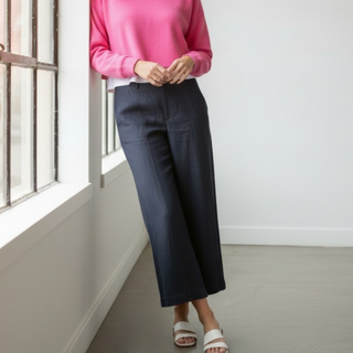 Michael Stars April wide leg trouser in nocturnal blue with cropped wide leg silhouette and front seam detail styled on model by window lifestyle view