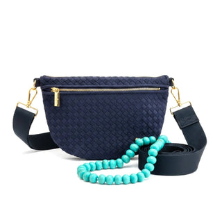 Navy suede woven Westlyn bum bag with interchangeable strap and aqua beaded accessory flat lay view
