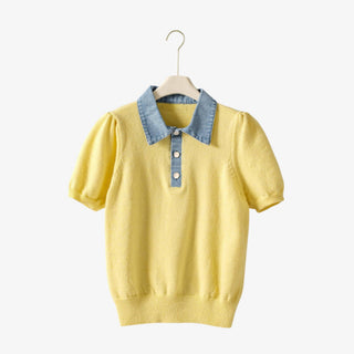 Yellow sweater with denim collar on a hanger against a white background