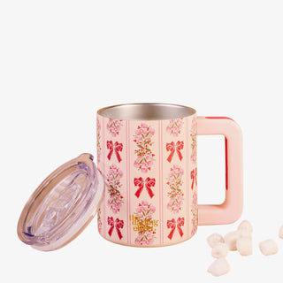 Pink mug with floral and bow pattern on a white background