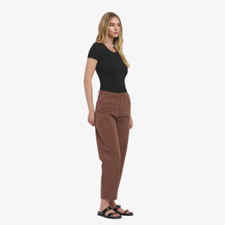 Woman wearing high rise brown barrel jeans with ankle length fit and relaxed leg
