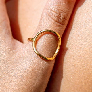Gold sculptural wave ring close-up detail on finger