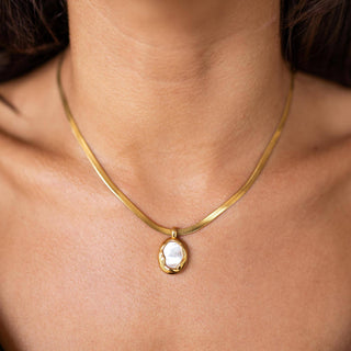 Gold pendant necklace with mother of pearl charm close-up front view