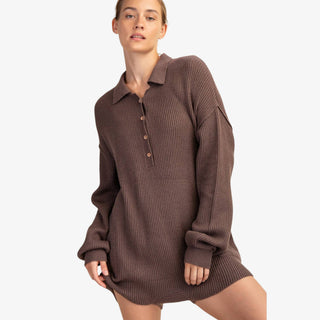 Woman wearing ribbed knit sweater romper with collared neckline and button front
