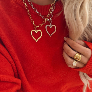 Open heart necklace in 18K gold plated finish with adjustable chain worn layered on model