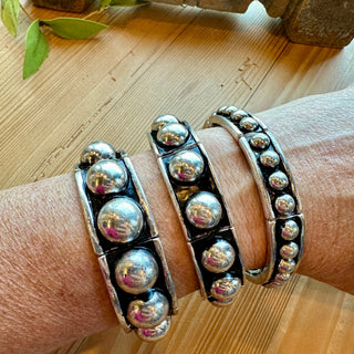 Modern silver dome stretch bracelet with polished rounded beads worn on wrist