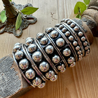 Modern silver dome stretch bracelet with polished rounded beads worn on wrist