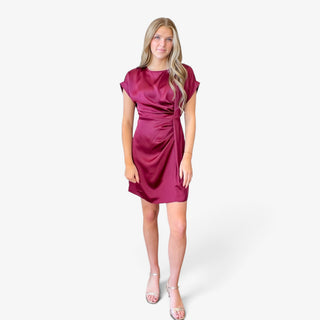 Burgundy satin fit and flare mini dress with short cuffed sleeves, round neckline and flattering gathered waist, front view styled with silver heels.