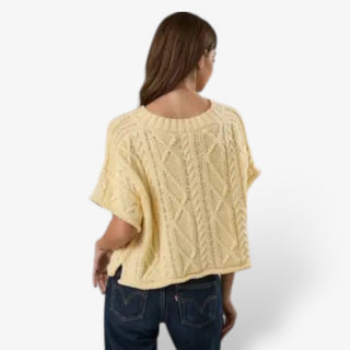 Butter yellow cable knit short sleeve sweater for women shown from the back with a relaxed drape, ribbed neckline and allover cable pattern.