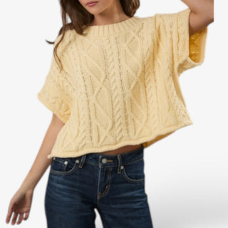 Butter yellow cable knit short sleeve sweater for women shown in a movement view highlighting the relaxed boxy fit, wide sleeves and cable texture.