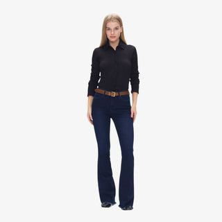 Woman wearing Mid Rise Flare Jeans in deep-water indigo denim with brown belt and black top, styled with heeled boots.