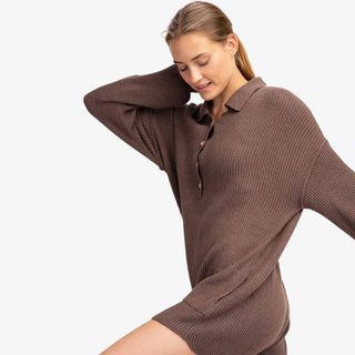 Woman wearing ribbed knit sweater romper with collared neckline and button front