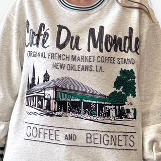 Queen of Sparkles grey Café Du Monde sweatshirt with green sport-stripe neckline and sequin graphic.