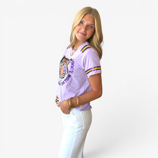 Lavender sequin tiger graphic tee with purple and gold striped sleeves styled with white jeans, angled front view