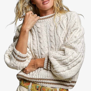 Cream cable knit sweater close-up showing textured cable knit pattern and soft chunky knit detail