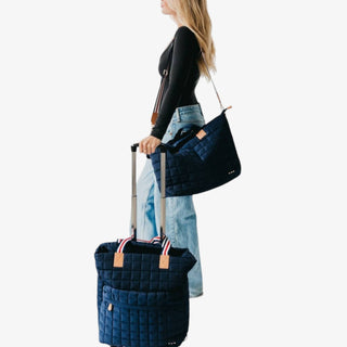 Jetsetter Quilted Rolling Tote in navy with quilted design, dual handles, and telescopic handle on wheels