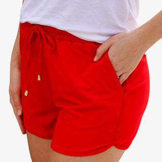 Red drawstring shorts with elastic waistband and pockets styled with patriotic star top front view