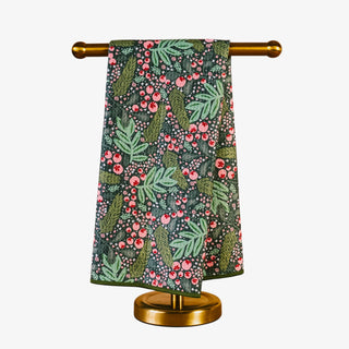 Floral patterned towel hanging on a gold towel rack against a white background