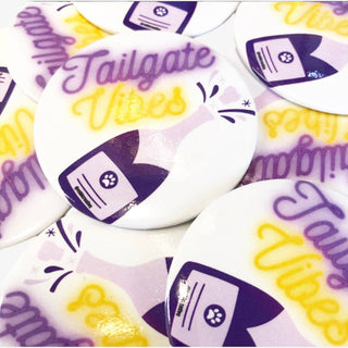 Tailgate Vibes button in purple and gold with champagne bottle graphic, perfect for game day spirit accessory