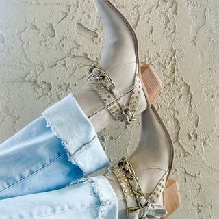 Diba True Paper Lily suede ankle boots styled with light-wash jeans against a textured wall, lifestyle view