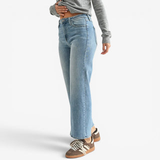 Medium wash cropped wide leg jeans shown from the side to highlight the high rise and fit through the hips