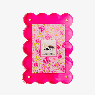Pink scalloped photo frame with floral design and 'the darling effect' branding on a white background