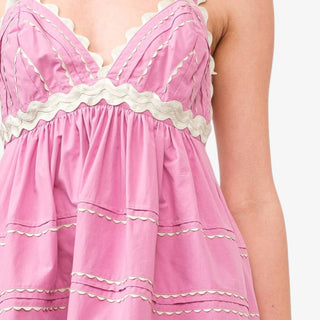 Pink midi dress with scallop trim and lace detail featuring empire waist and wide straps styled with neutral heels