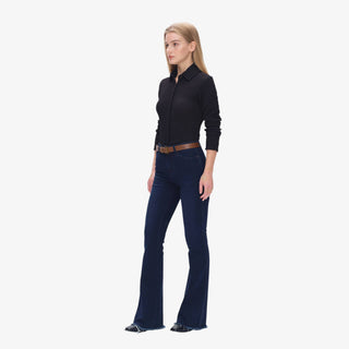 Woman wearing Mid Rise Flare Jeans in deep-water indigo denim with brown belt and black top, styled with heeled boots.