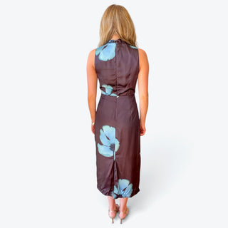 Brown and blue floral midi dress featuring a fitted sleeveless bodice, back seam and center back slit, modeled from the rear.