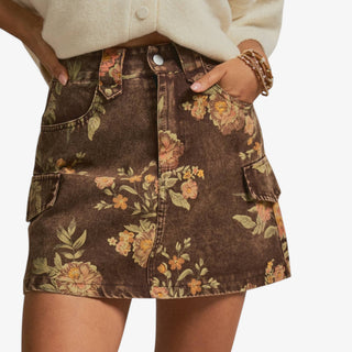 Floral denim cargo skirt in washed brown with vintage peach and sage blooms and oversized pockets, styled front view