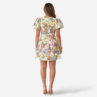 Floral rosette mini dress with puff sleeves, fitted waist and centered back zipper, modeled from the back