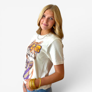 Women’s heather cream tiger rhinestone tee shown from the side with relaxed short sleeves and purple-and-gold graphic detail