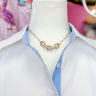 Gold pearl necklace by Kitzi Perry styled with a white and blue collared top, front outfit view