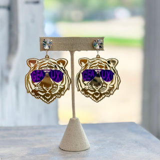 Gold mirrored tiger game day earrings with purple Geaux sunglasses and crystal-style studs displayed on a jewelry stand, front view.