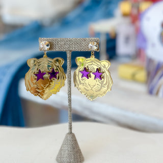 Gold mirrored tiger game day earrings with purple star eyes and crystal studs displayed on a jewelry stand, lifestyle front view.