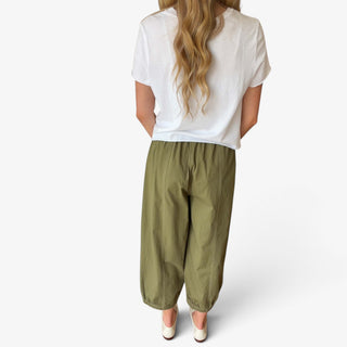 Olive green cotton balloon pants with relaxed fit, contrast seam stitching and gathered ankle hems, back view