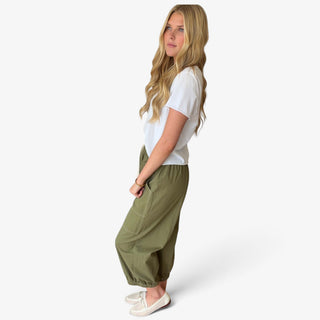 Mossy olive green cotton balloon pants with relaxed balloon silhouette, side patch pocket and gathered ankle hem, side view