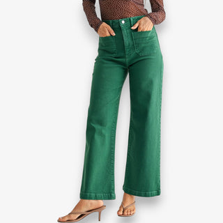 Green high-rise wide leg jeans with structured denim and full-length fit styled with heels on white background