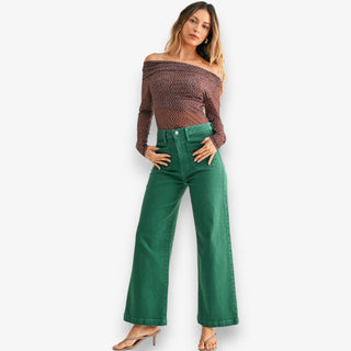 Green high-rise wide leg jeans with structured denim and full-length fit styled with heels on white background
