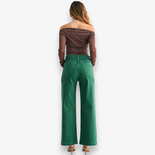 Green high-rise wide leg jeans with structured denim and full-length fit styled with heels on white background